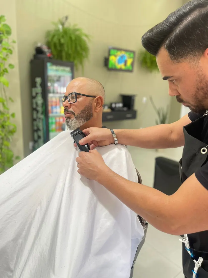 Sildo aparando a barba de um cliente na barbearia do Studio Oásis