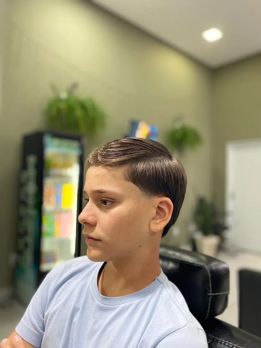 Corte jovem com degradê na barbearia do Studio Oásis